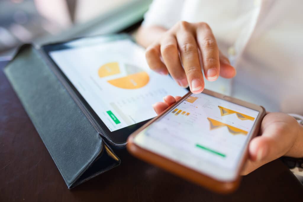 Woman conducting keyword research on a tablet and mobile device.