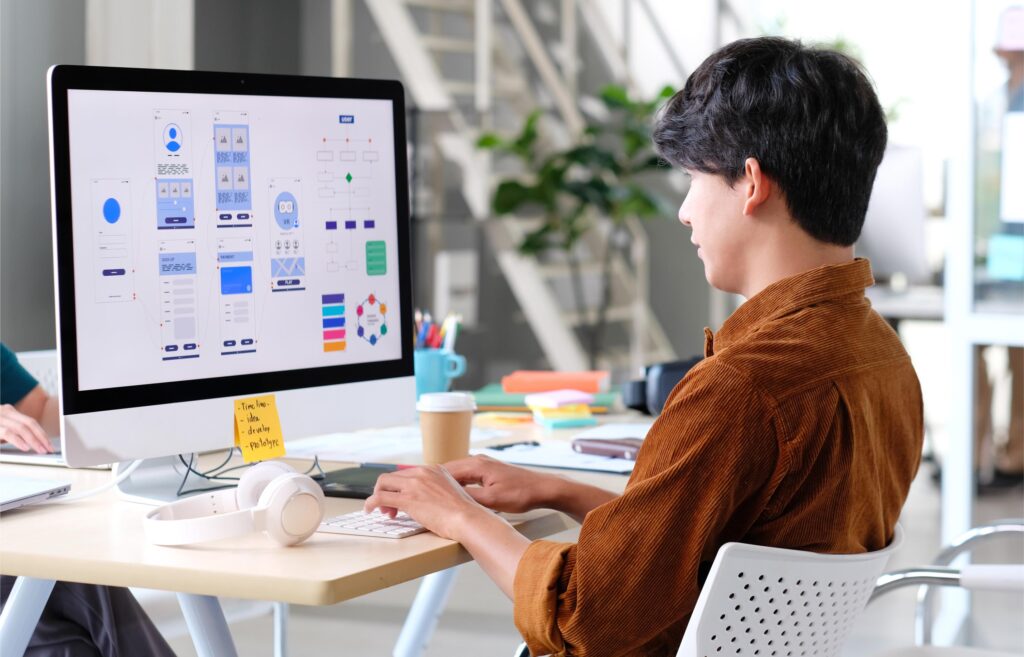 Front-end developer designing responsive user interfaces on a desktop computer using component-based design principles in modern web development.