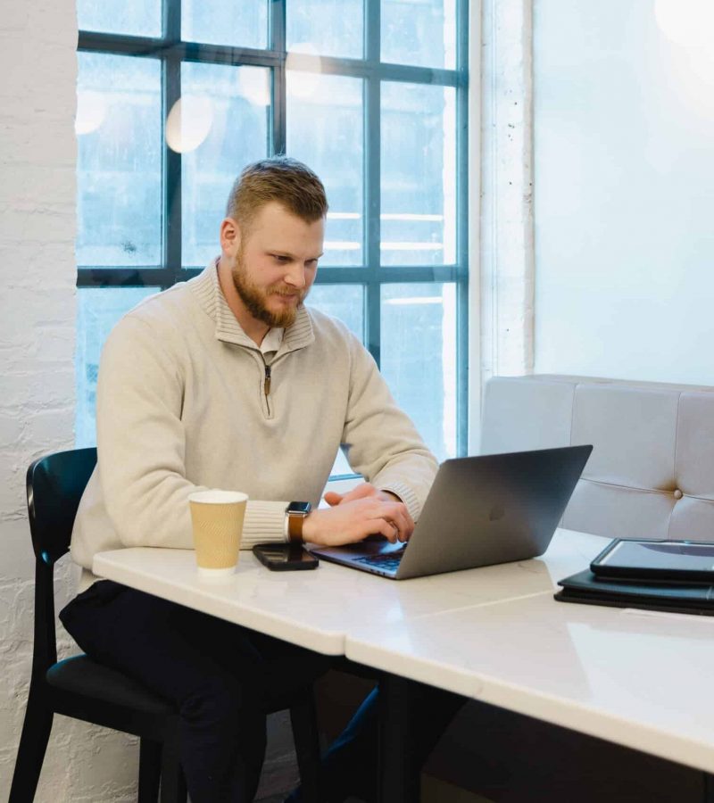 Owner Of An Omaha Seo &Amp; Web Design Company Working On Laptop In A Modern Office.